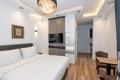a bedroom with a white bed and a dining room at Boutique 360 Suite in Istanbul