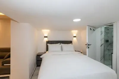 a bedroom with a white bed and a glass shower at Boutique 360 Suite in Istanbul