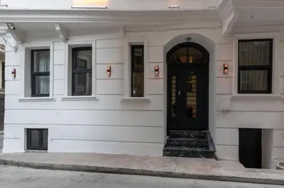 a white building with a black door and stairs at Boutique 360 Suite in Istanbul
