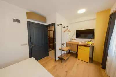 a room with a bed and a desk and a television at Pastel İstanbul in Istanbul