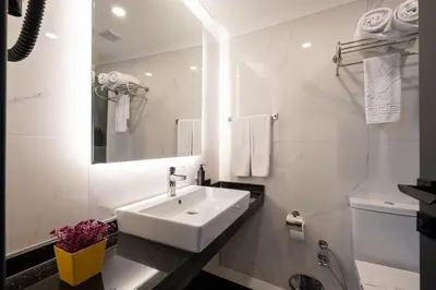 a white bathroom with a sink and a mirror at 216 Star in Samandra
