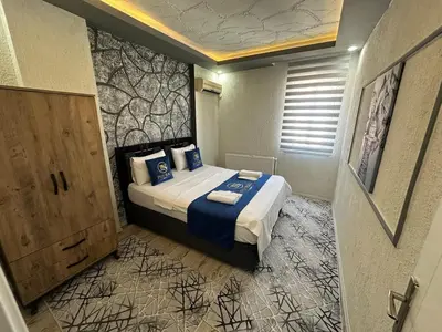 a bedroom with a bed with blue pillows at Poyraz suit in Bursa