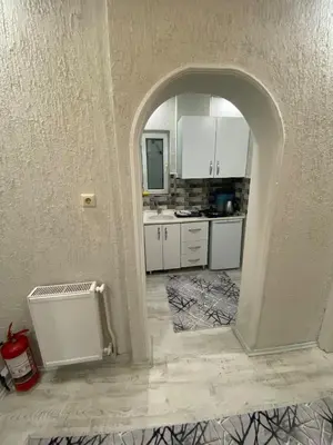 a kitchen with an archway and white cabinets at Poyraz suit in Bursa
