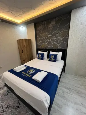 a hotel room with a bed with blue and white pillows at Suit 2 in Bursa