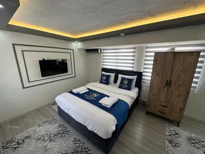 a bedroom with a large bed with blue pillows at Poyraz suit in Bursa