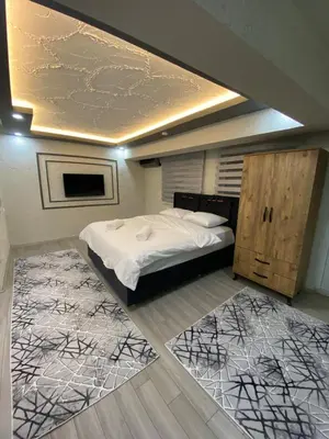a bedroom with a bed and two rugs at Poyraz suit in Bursa