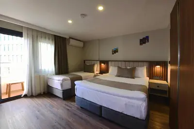 a hotel room with two beds and a window at Hotel Öncü in Istanbul