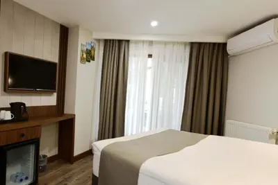 a hotel room with a bed and a flat screen tv at Hotel Öncü in Istanbul