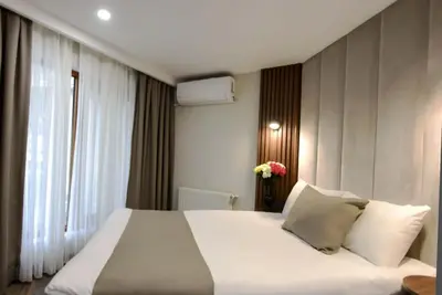 a bedroom with a large white bed and a window at Hotel Öncü in Istanbul