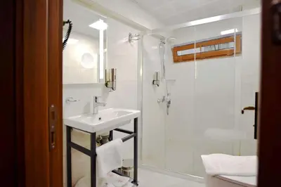a white bathroom with a sink and a shower at Hotel Öncü in Istanbul