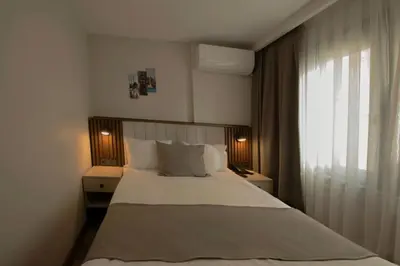 a bedroom with a large white bed with a window at Hotel Öncü in Istanbul