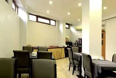 a restaurant with a table and chairs and a counter at Hotel Öncü in Istanbul