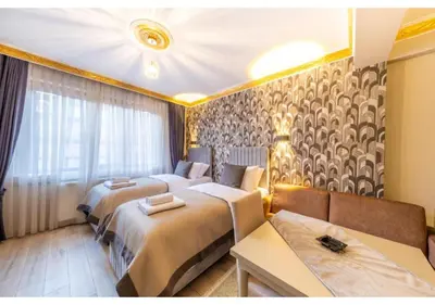 a hotel room with two beds and a couch at Taksim Studio Apart in Istanbul