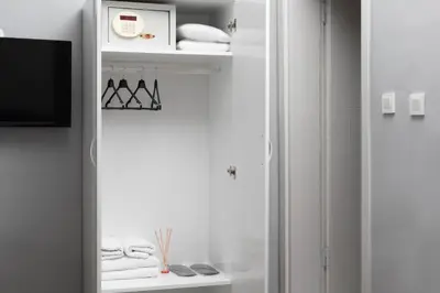 a white room with a tv and a shelf with hangers at Galley Port in Istanbul