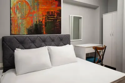 a bedroom with a white bed with a painting on the wall at Galley Port in Istanbul