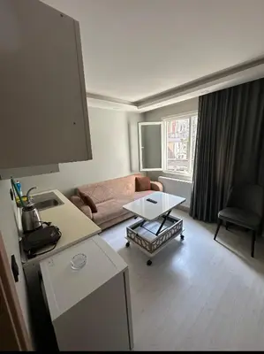 a living room with a couch and a table at Cihangir Galataport Hotel in Istanbul