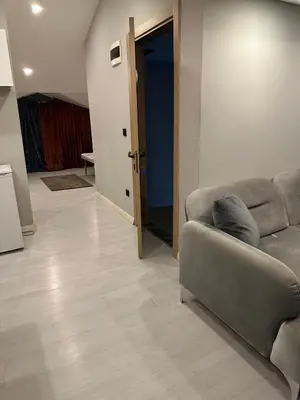a living room with a couch and a hallway at Cihangir Galataport Hotel in Istanbul