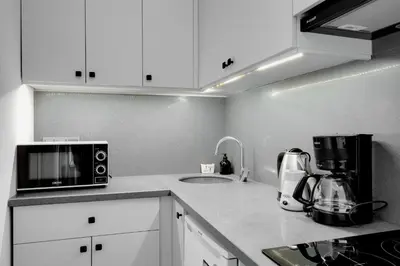 a white kitchen with a microwave and a sink at Newly Constructed in Kadikoy Quake-Resistant-AC in Istanbul