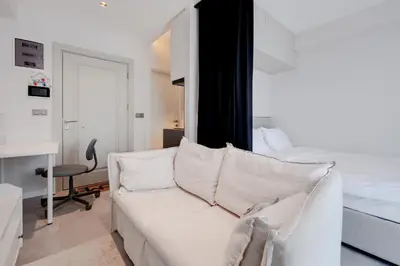 a living room with a white couch and a bed at Newly Constructed in Kadikoy Quake-Resistant-AC in Istanbul
