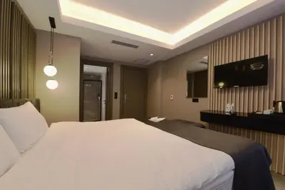 a bedroom with a white bed and a flat screen tv at Mery Hotel İstanbul in Istanbul