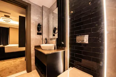 a bathroom with a sink and a black wall at Mery Hotel İstanbul in Istanbul