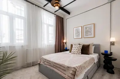 a bedroom with a bed with white walls and windows at Lovely City Apartment Steps Away from Galata Tower in Istanbul