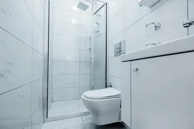 a white bathroom with a toilet and a shower at Lovely City Apartment Steps Away from Galata Tower in Istanbul