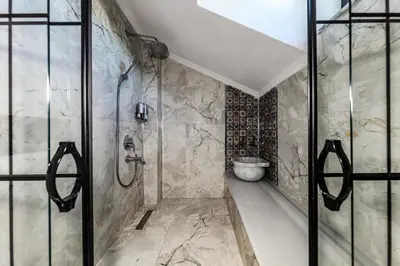 a bathroom with a shower and a toilet at AirGate Airport Hotel in Arnavutköy