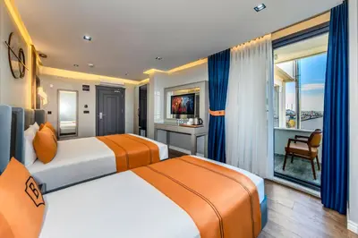 two beds in a hotel room with a view at AirGate Airport Hotel in Arnavutköy