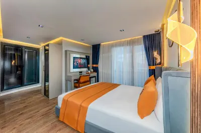 a bedroom with a bed and a desk and a television at AirGate Airport Hotel in Arnavutköy