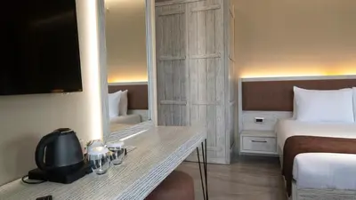 a hotel room with a bed and a desk with a mirror at Magical House Hotel in Çatalca
