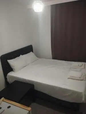 a bedroom with a bed with white sheets and a light at Şişli Suites - Room49 in Istanbul