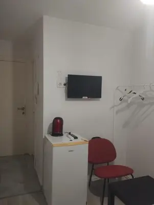 a small kitchen with two chairs and a tv on the wall at Şişli Suites - Room49 in Istanbul