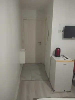a small kitchen with a refrigerator and a door at Şişli Suites - Room49 in Istanbul