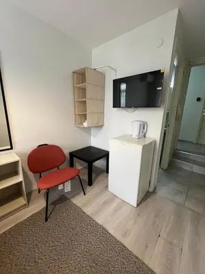a small kitchen with a red chair and a refrigerator at Şişli Suites - Room45 in Istanbul
