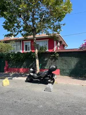 a motorcycle parked on the street in front of a house at Şişli Suites - Room45 in Istanbul