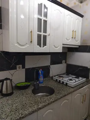 a kitchen counter with a sink and white cabinets at Hilal Aparment Basement in Istanbul