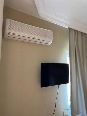 a television on a wall with a air conditioner at Otel in Kumbağ