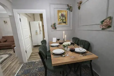a dining room with a wooden table and green chairs at Ayasofya Bella Vista APART in Istanbul