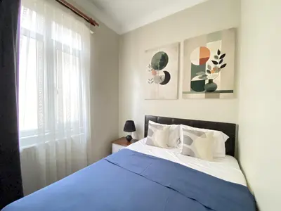 a bedroom with a bed with blue sheets and a window at Charming Vintage 3BR in the Heart of Beyoğlu in Istanbul