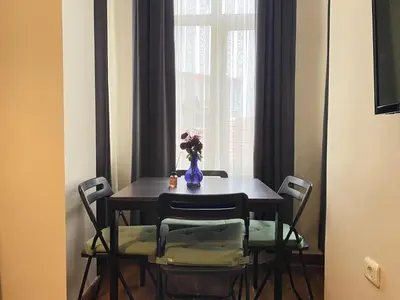 a dining room table with chairs and a vase with flowers at Charming Vintage 3BR in the Heart of Beyoğlu in Istanbul