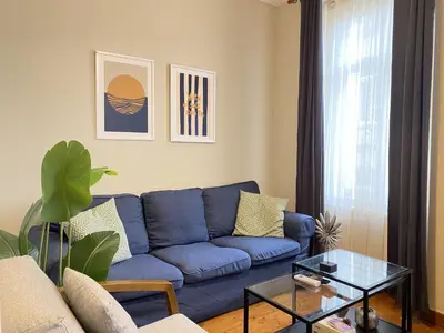 a living room with a blue couch and a glass table at Charming Vintage 3BR in the Heart of Beyoğlu in Istanbul