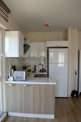 a kitchen with white cabinets and a white refrigerator at King Suite SN20 in Esenyurt