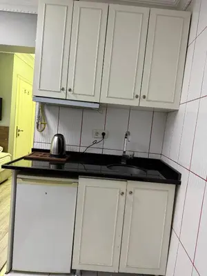 a kitchen with white cabinets and a sink at Holiday Suit in Istanbul
