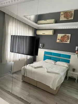 a bedroom with a large bed with a blue headboard at Holiday Suit in Istanbul