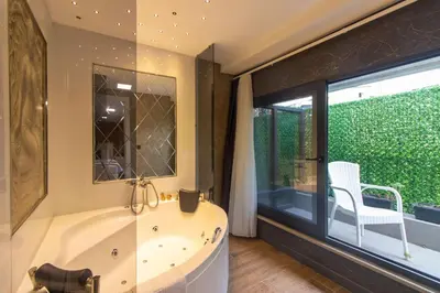 a bathroom with a tub and a chair next to a window at Nomad Hub Suit İstanbul in Istanbul