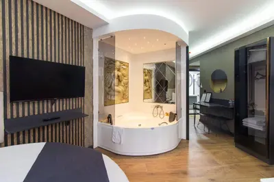 a bedroom with a tub and a television in a room at Nomad Hub Suit İstanbul in Istanbul