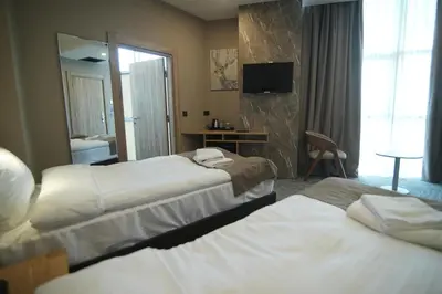 a hotel room with two beds and a mirror at Kent Room Hotel in Kapaklı