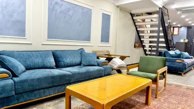 a living room with a blue couch and two chairs at Miller Home's in Istanbul