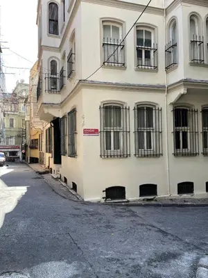 a white building with barred windows on a street at Ozcans Pera Flats 2 in Istanbul